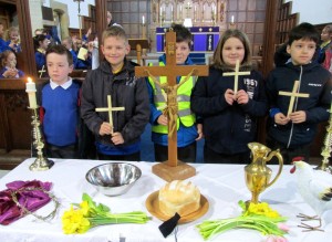 Students next to the table upon which are items representative of the Passion and Resurrection of Jesus.